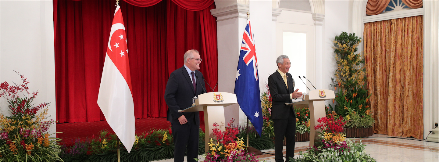 Scott Morrison and Lee Hsien Loong at podiums with Singapore and Australian flags.
